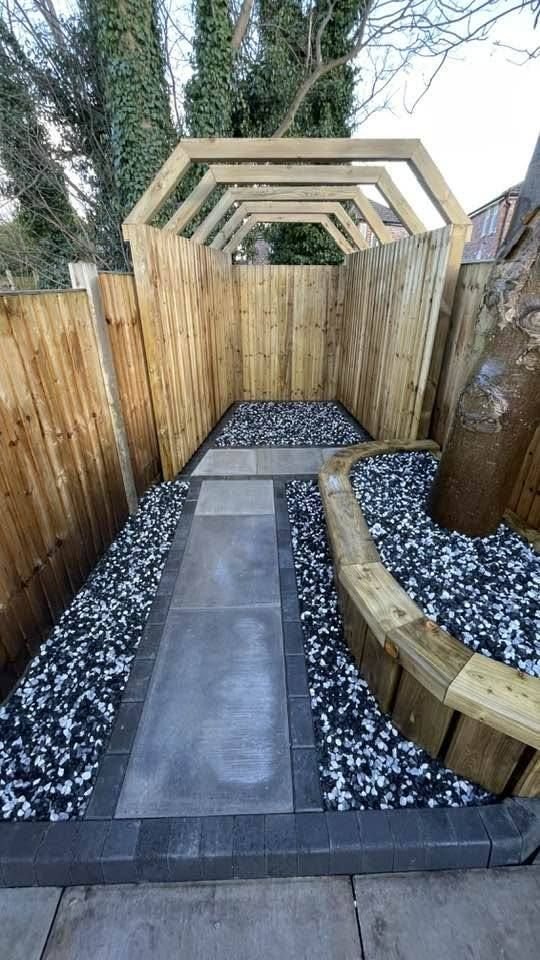 Gravel garden with black and white stone chippings and raised sleeper beds by RY Garden & Landscaping
