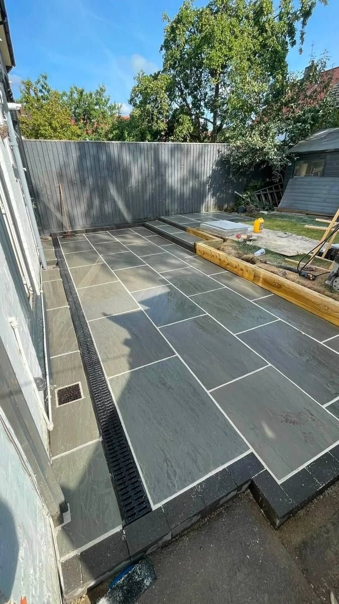 Dark grey slate patio with drainage channel installed by RY Garden & Landscaping